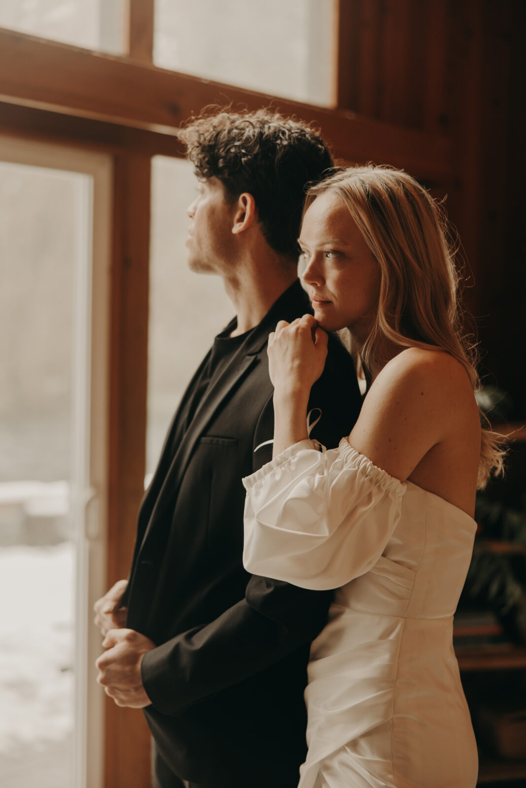 couple getting ready together in cabin before forest elopement