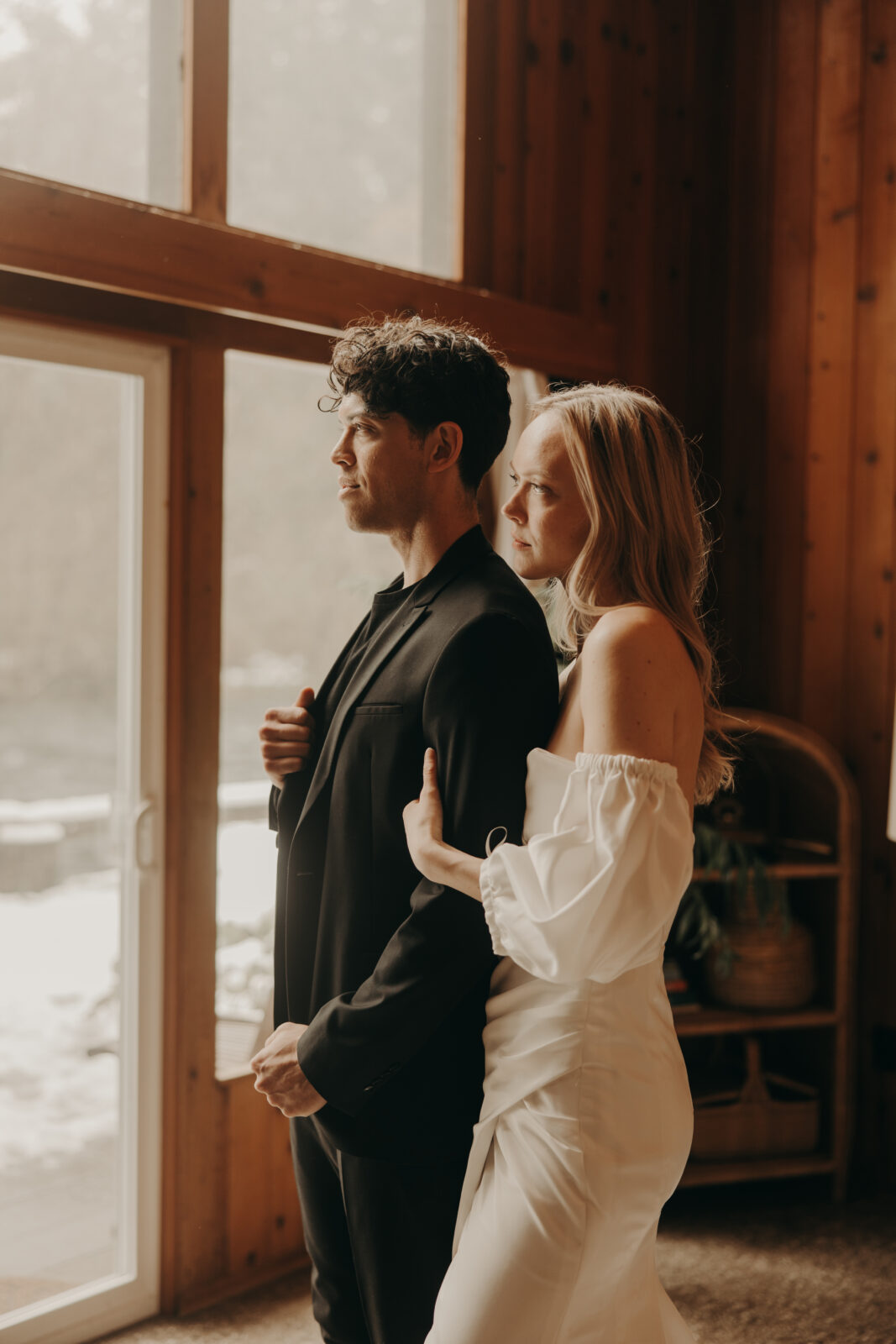 couple getting ready together in cabin before forest elopement