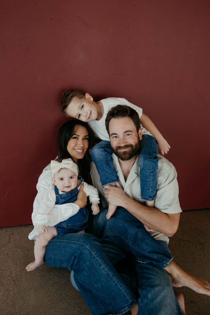 Family smiling together during a studio photoshoot with soft natural lighting