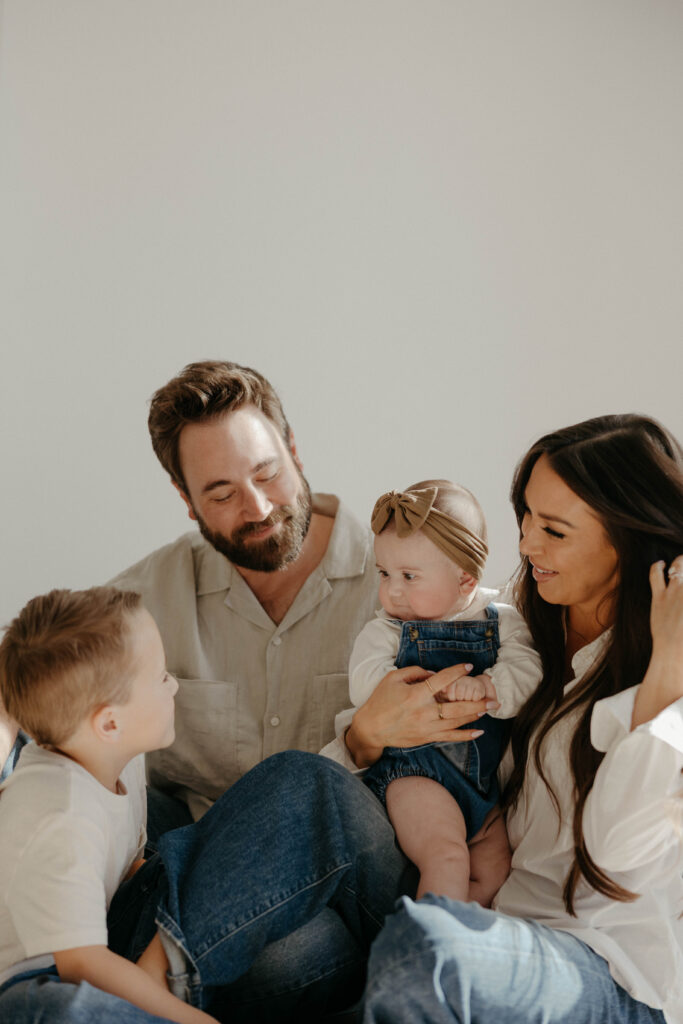 Parents holding their toddlers during a bright and airy indoor family session.