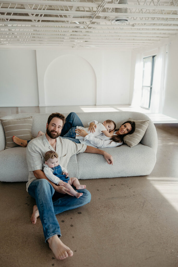 Family smiling together during a studio photoshoot with soft natural lighting