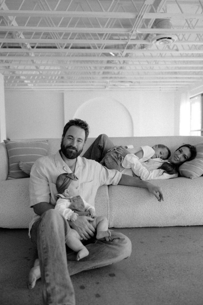 Family smiling together during a studio photoshoot with soft natural lighting